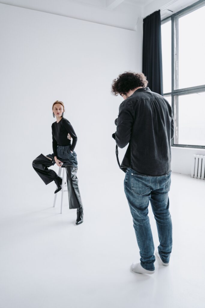 Photographer capturing a model in a sleek, modern studio setting.